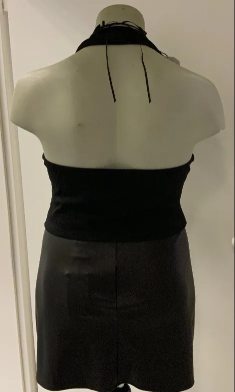 The seller’s phone photo of the corset halter and wet-look skirt on a shop mannequin, back view showing the halter tie