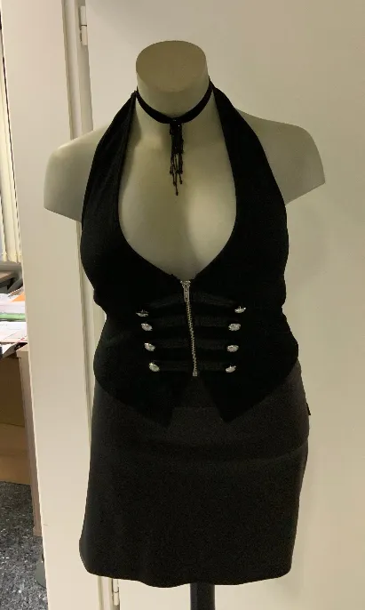 The seller’s phone photo of the black corset halter top, beaded choker and wet-look skirt on a shop mannequin, front view