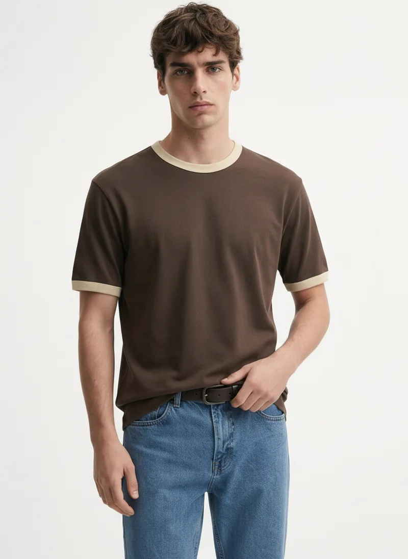 MODA AI output — model in the brown ringer tee tucked into belted jeans, front, belt visible at the waist