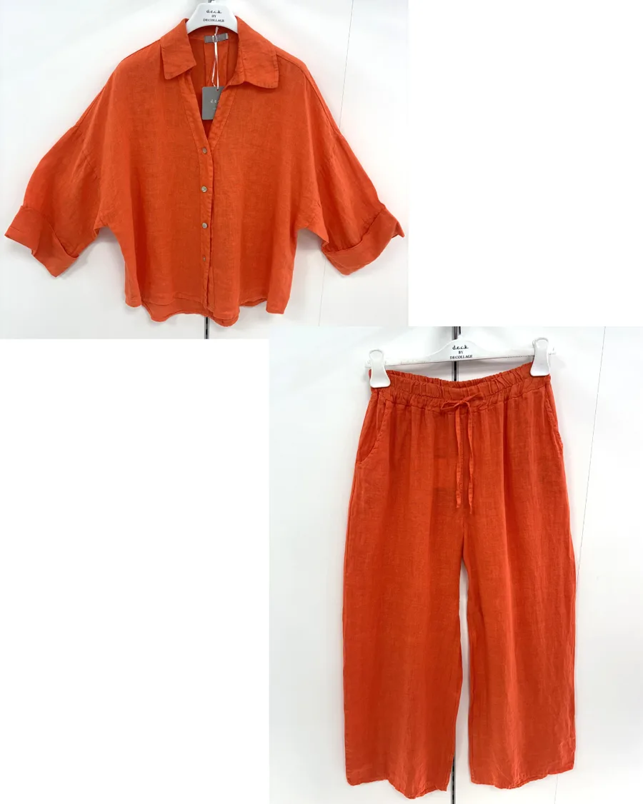 Input flat lay composed in a layout tool — an orange cropped linen shirt and matching wide-leg trousers arranged together on white