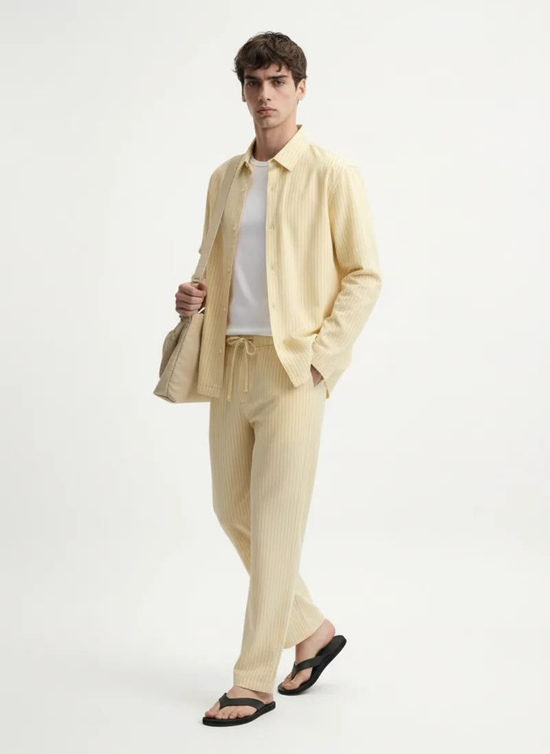 MODA AI output — model in the yellow overshirt and trousers, front full length
