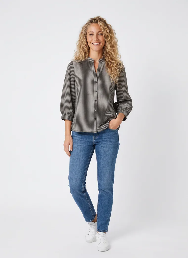 MODA AI on-model output — the striped shirt styled with blue jeans and white trainers, additional catalog angle, generated from a hanger shot in the same clean studio as the rest of the collection