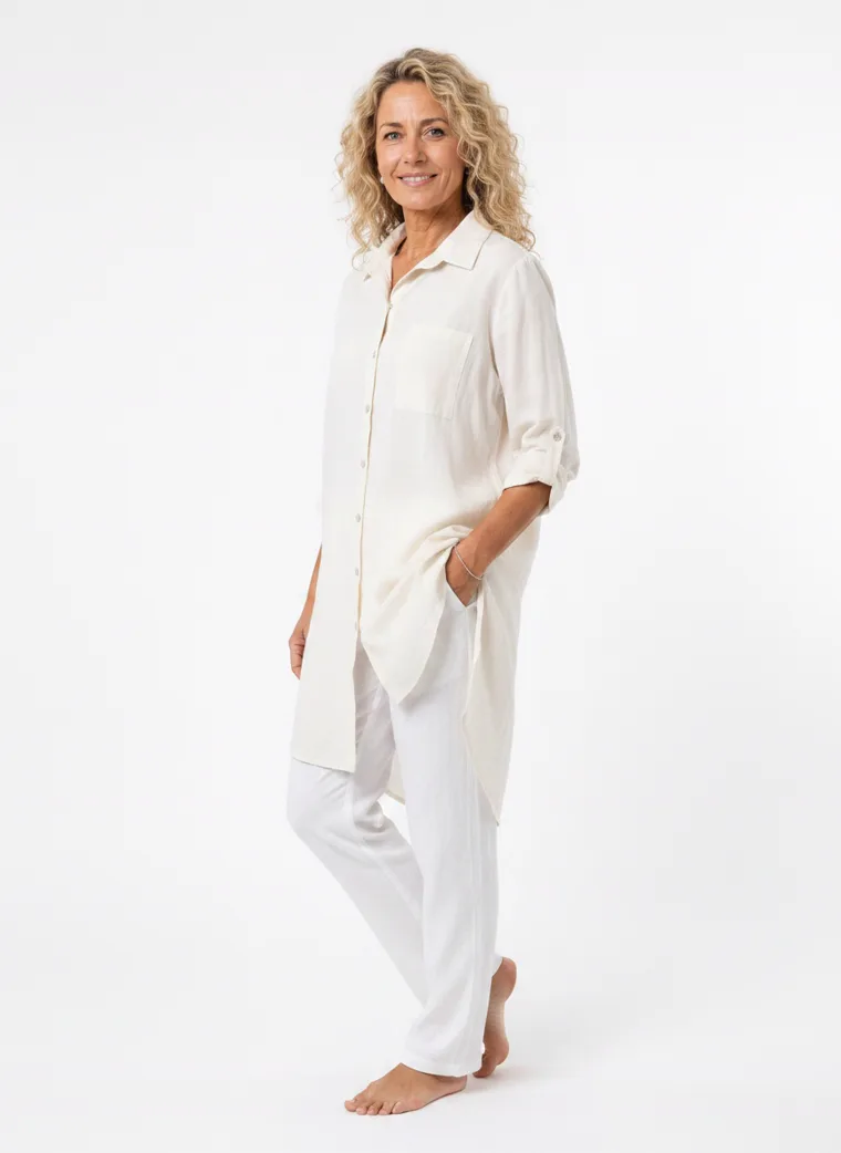 MODA AI on-model output — the cream shirt dress worn over white trousers, additional catalog angle, generated from a hanger shot in the same clean studio as the rest of the collection