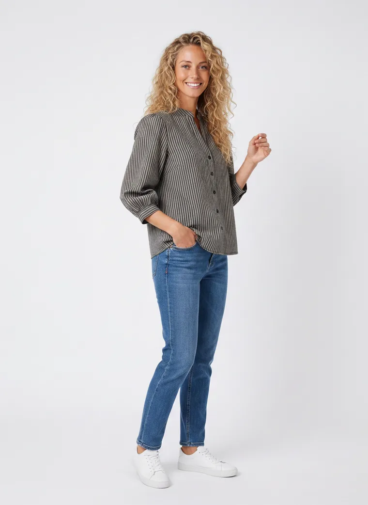 MODA AI on-model output — the striped shirt styled with blue jeans and white trainers, additional catalog angle, generated from a hanger shot in the same clean studio as the rest of the collection