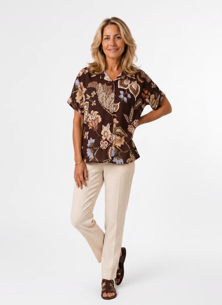MODA AI on-model output — the brown floral short-sleeve blouse styled with cream trousers, additional catalog angle, generated from a hanger shot in the same clean studio as the rest of the collection