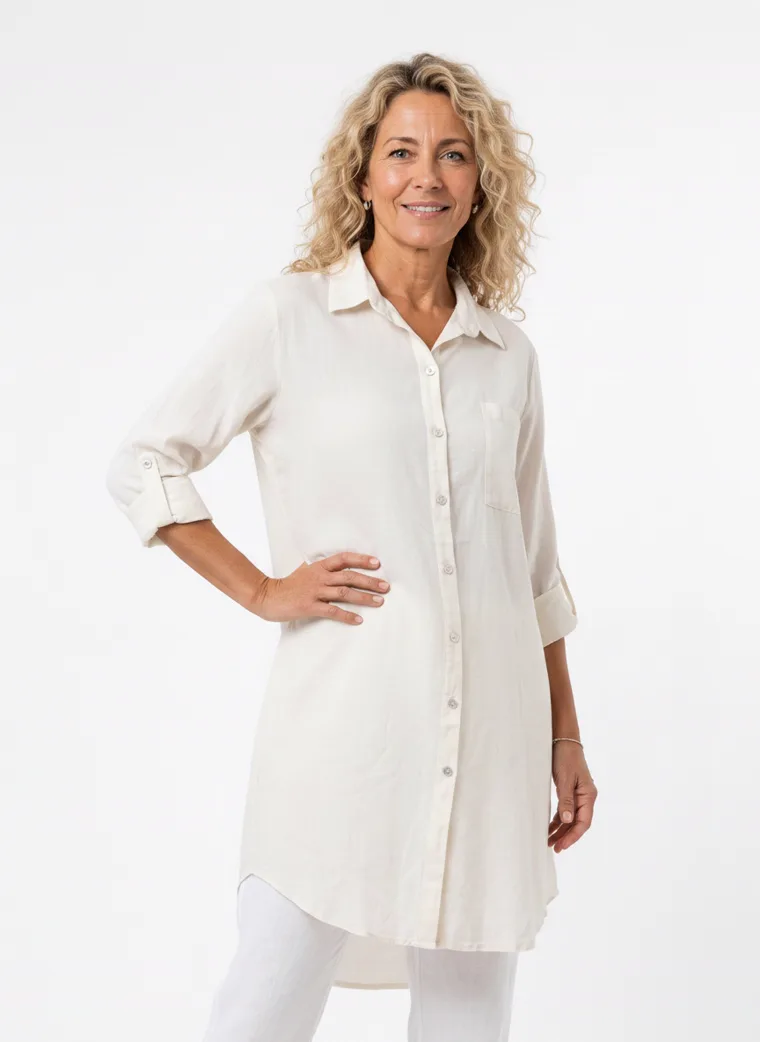 MODA AI on-model output — the cream shirt dress worn over white trousers, additional catalog angle, generated from a hanger shot in the same clean studio as the rest of the collection