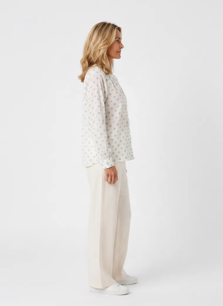 MODA AI on-model output — the white dotted blouse styled with cream trousers, additional catalog angle, generated from a hanger shot in the same clean studio as the rest of the collection