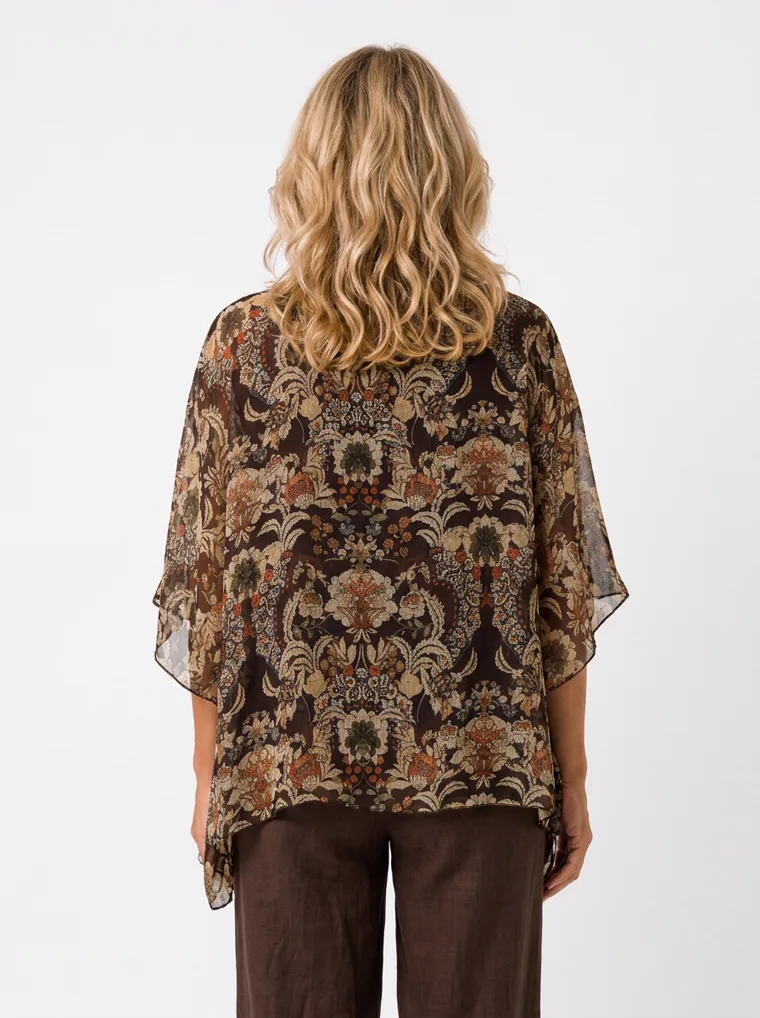 MODA AI on-model output — the paisley kaftan top styled with brown wide-leg trousers, back view, generated from a hanger shot in the same clean studio as the rest of the collection