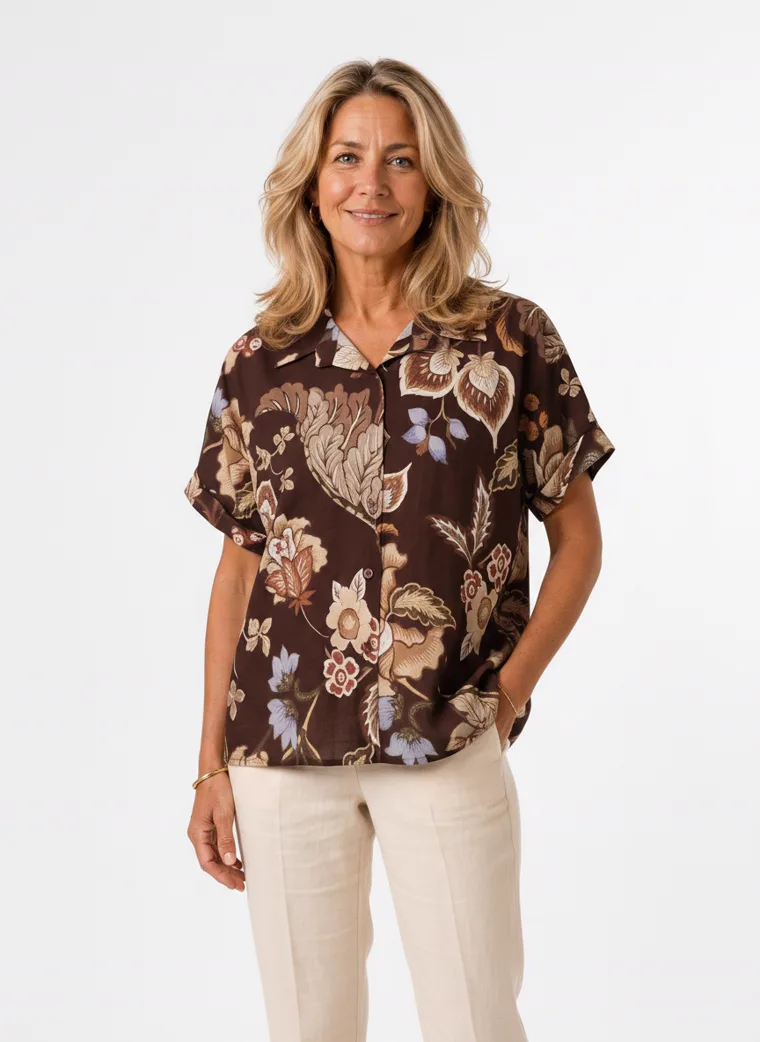 MODA AI on-model output — the brown floral short-sleeve blouse styled with cream trousers, additional catalog angle, generated from a hanger shot in the same clean studio as the rest of the collection