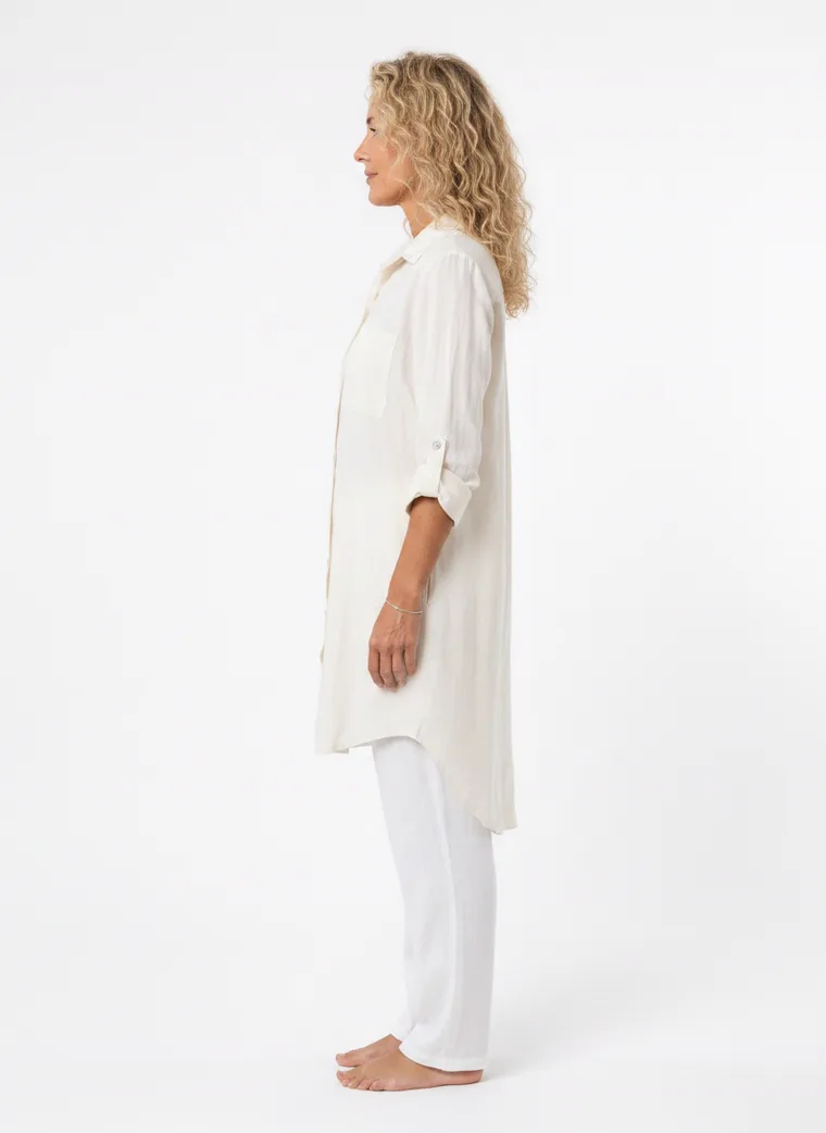 MODA AI on-model output — the cream shirt dress worn over white trousers, additional catalog angle, generated from a hanger shot in the same clean studio as the rest of the collection