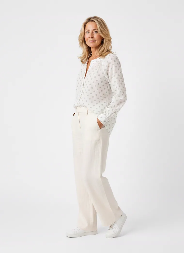 MODA AI on-model output — the white dotted blouse styled with cream trousers, additional catalog angle, generated from a hanger shot in the same clean studio as the rest of the collection