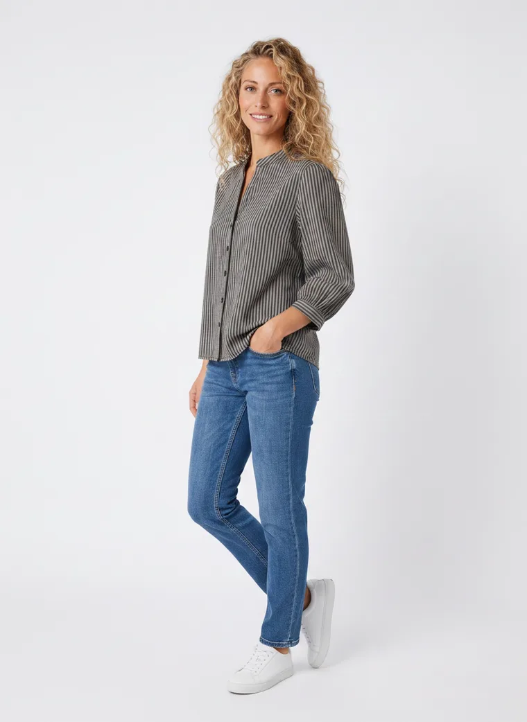 MODA AI on-model output — the striped shirt styled with blue jeans and white trainers, additional catalog angle, generated from a hanger shot in the same clean studio as the rest of the collection