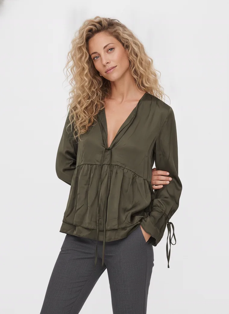 MODA AI output — the olive tiered blouse worn by a model, three-quarter view showing the V neckline and tiered seam