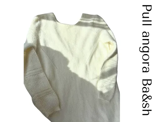 The starting photo for the cream v-neck knit: the cream knit laid flat with a handwritten label