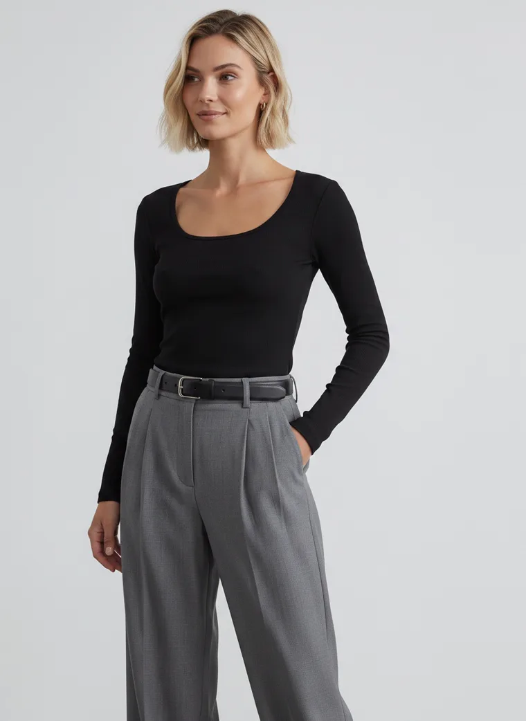 A black scoop-neck long-sleeve top with grey wide-leg trousers and a black belt, in a plain grey studio. Scoop-Neck Long-Sleeve Top in black, waist-up, three-quarter