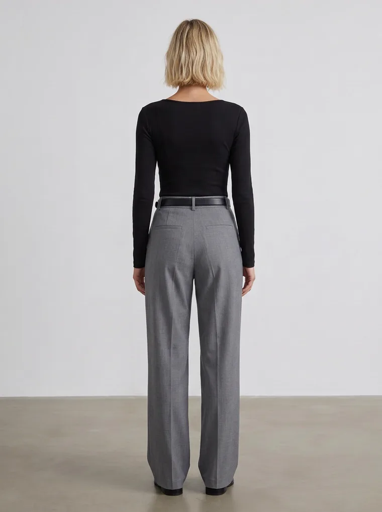 A black scoop-neck long-sleeve top with grey wide-leg trousers and a black belt, in a plain grey studio. Scoop-Neck Long-Sleeve Top in black, back view