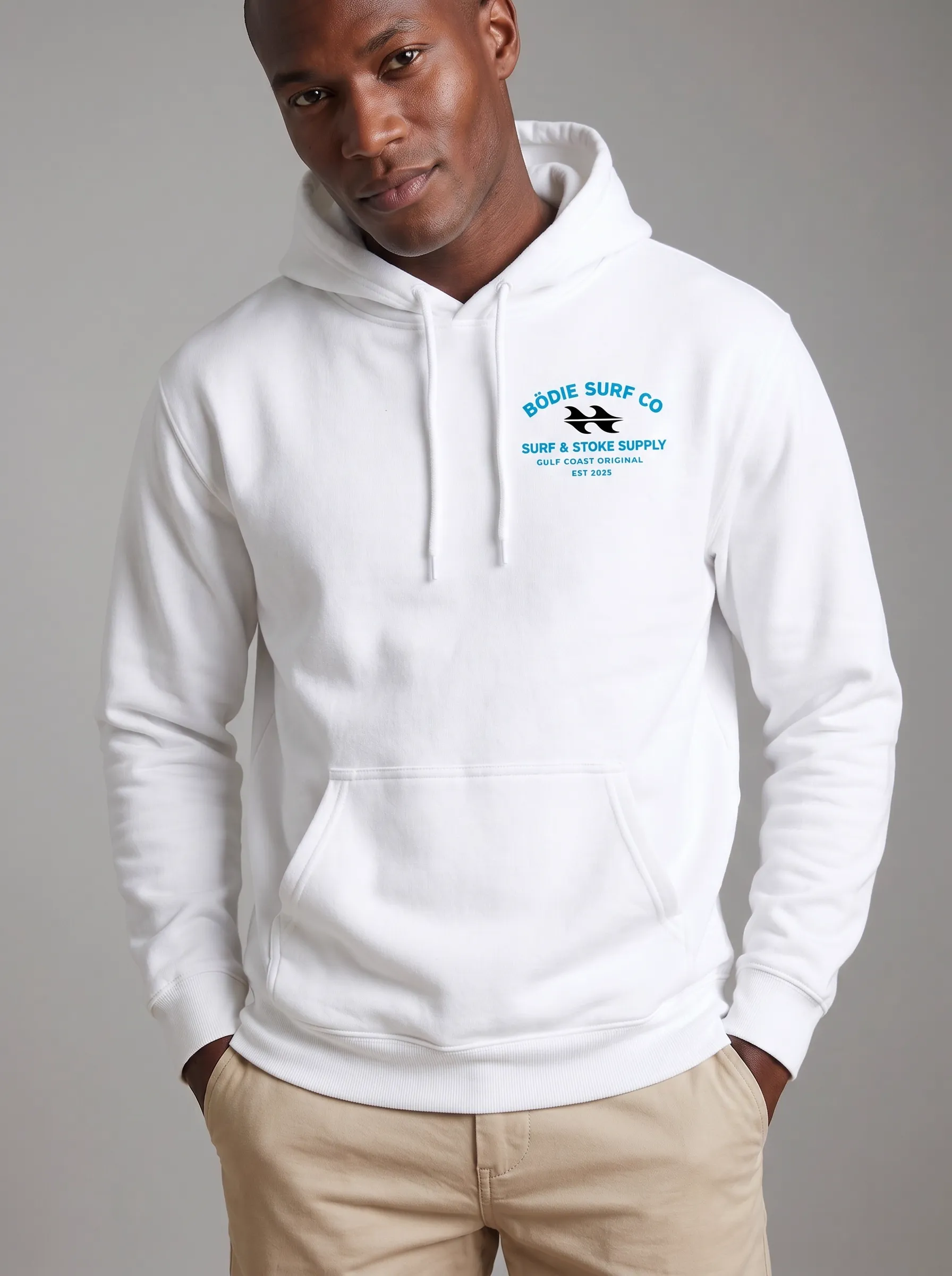 MODA AI logo reproduction — Black male model in white Bödie Surf Co hoodie with small chest badge reading 'Surf & Stoke Supply / Gulf Coast Original / Est 2025' fully legible at scale, demonstrating logo accuracy for Shopify branded apparel