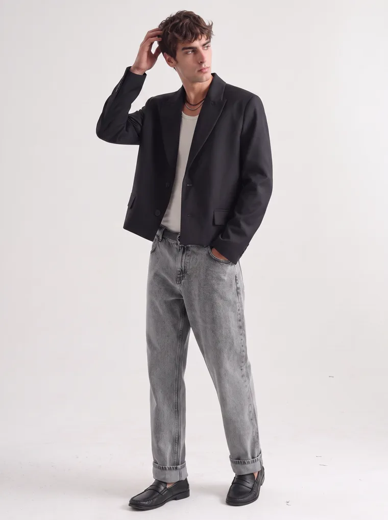 A black relaxed blazer over a cream tank with washed grey jeans and black boots on white. Relaxed Blazer in Black, frame 1 of 5