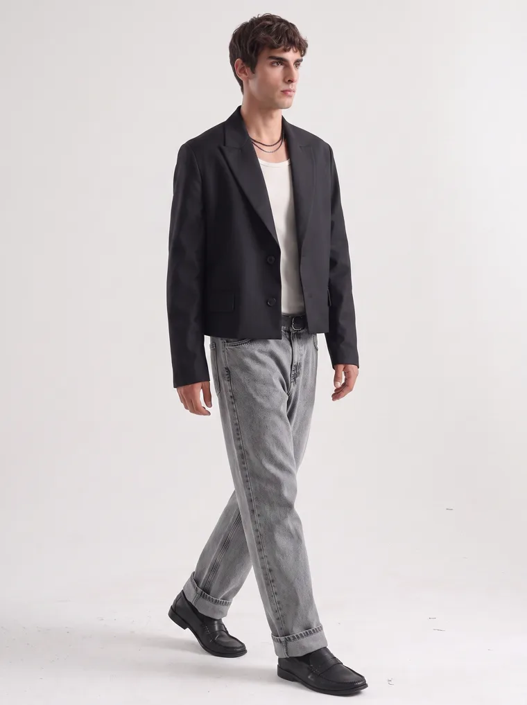 A black relaxed blazer over a cream tank with washed grey jeans and black boots on white. Relaxed Blazer in Black, frame 4 of 5