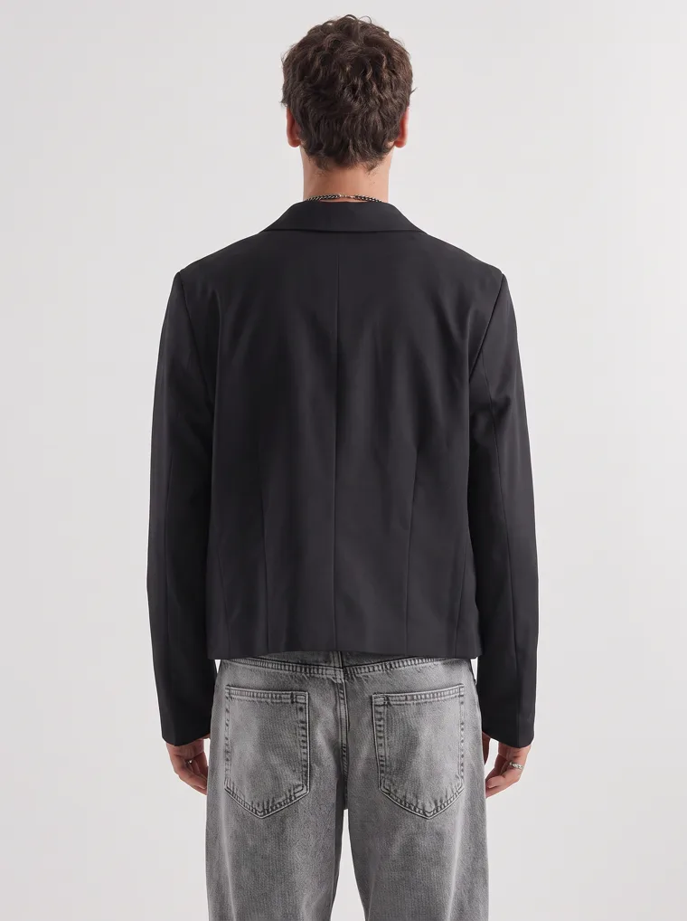 A black relaxed blazer over a cream tank with washed grey jeans and black boots on white. Relaxed Blazer in Black, frame 5 of 5
