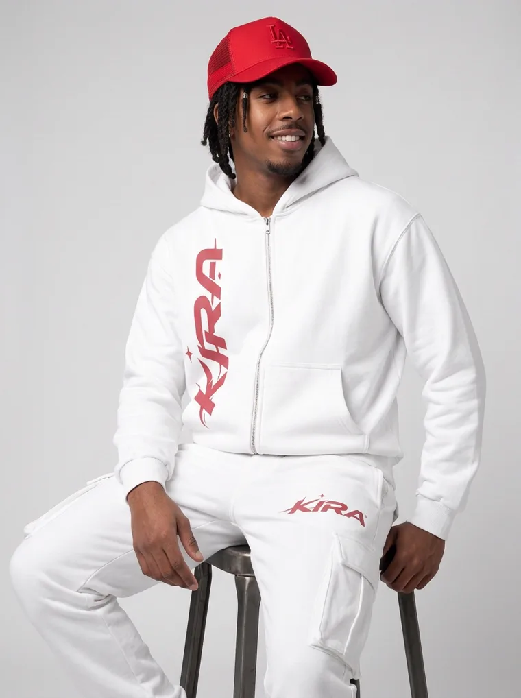 A white zip hoodie and cargo sweatpants with a red logo, red cap and red trimmed sneakers on light grey. Zip Hoodie Set in White, frame 1 of 5