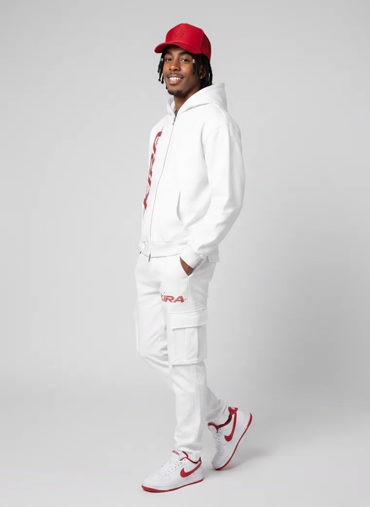 A white zip hoodie and cargo sweatpants with a red logo, red cap and red trimmed sneakers on light grey. Zip Hoodie Set in White, frame 2 of 5