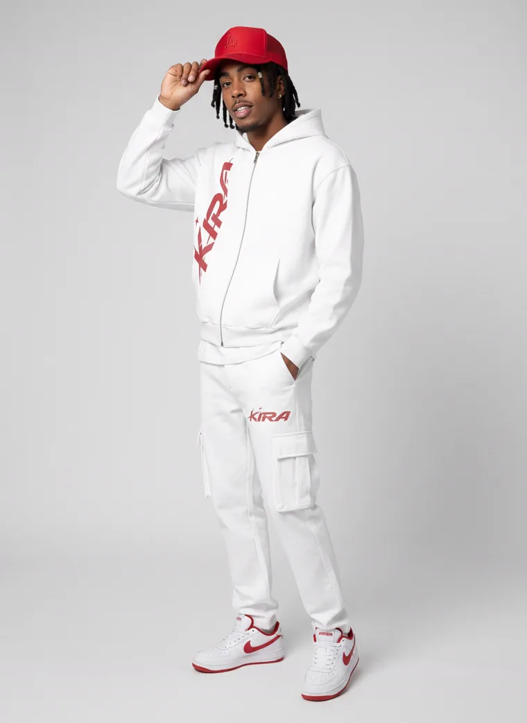 A white zip hoodie and cargo sweatpants with a red logo, red cap and red trimmed sneakers on light grey. Zip Hoodie Set in White, frame 5 of 5