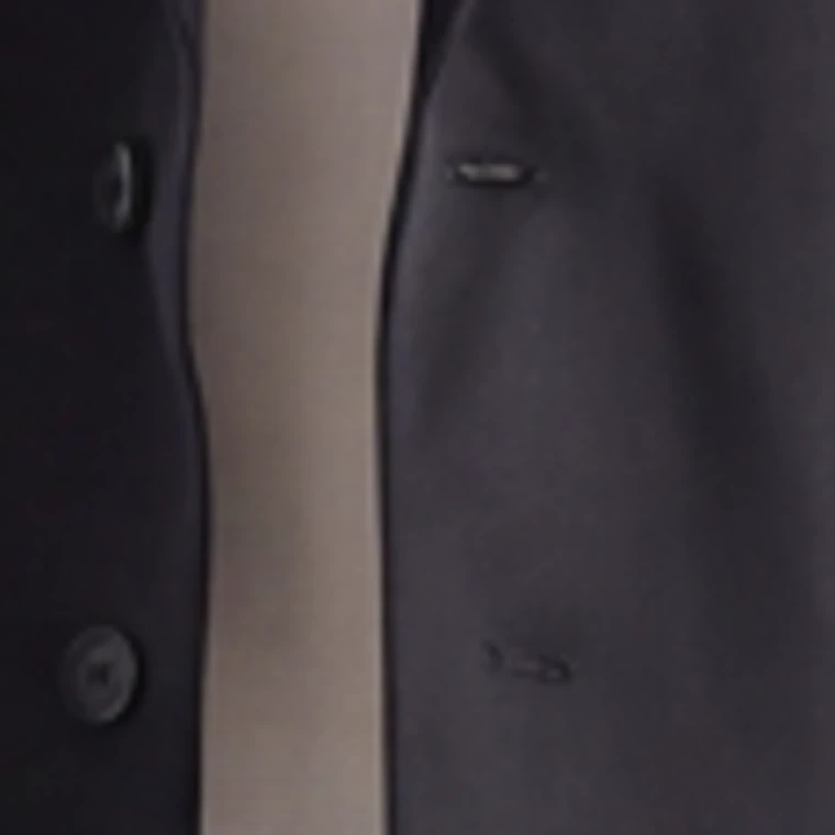 A square crop of the black blazer front from a 1K catalog frame, enlarged, the buttonhole stitching and belt buckle softened
