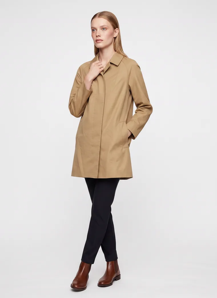 A camel car coat worn with black slim trousers and brown ankle boots on pale grey. Car Coat in Camel, frame 1 of 5
