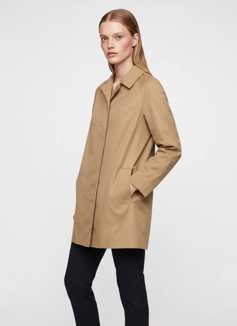 A camel car coat worn with black slim trousers and brown ankle boots on pale grey. Car Coat in Camel, frame 2 of 5