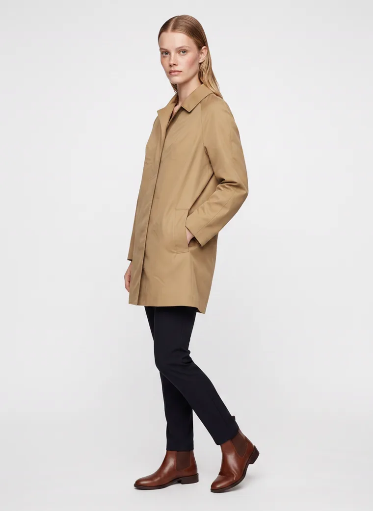 A camel car coat worn with black slim trousers and brown ankle boots on pale grey. Car Coat in Camel, frame 3 of 5