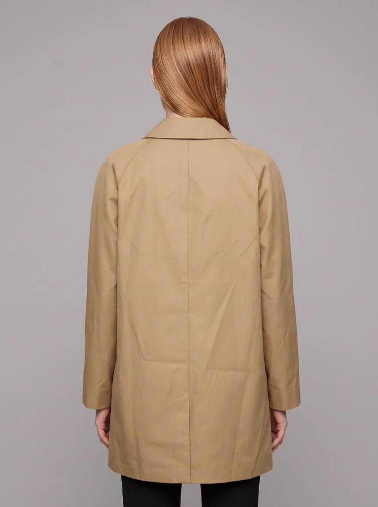 A camel car coat worn with black slim trousers and brown ankle boots on pale grey. Car Coat in Camel, frame 5 of 5