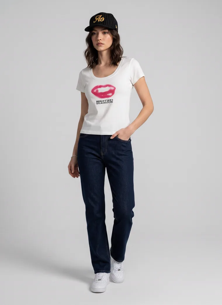 A fitted white tee with a pink lips graphic on the front and a rose print with lettering on the back, worn with dark indigo jeans and a black cap. Graphic Tee in White, frame 4 of 5