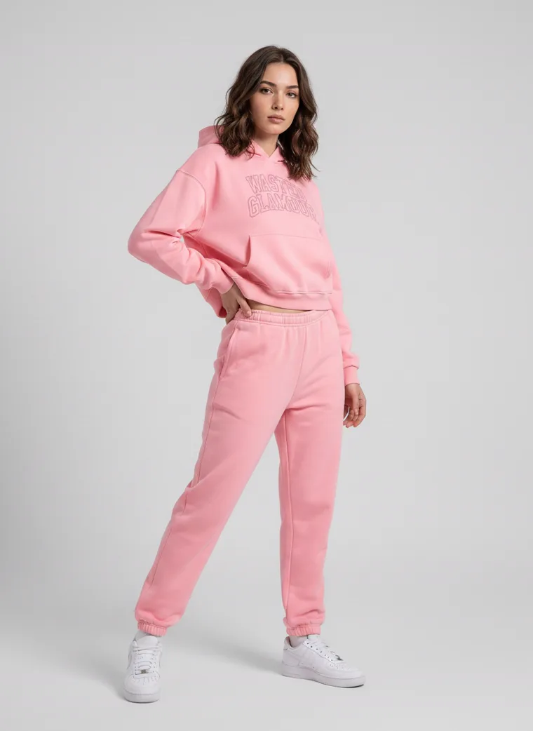 A pink hoodie with tonal collegiate lettering, styled with matching joggers and white sneakers on pale grey. Collegiate Hoodie in Pink, frame 4 of 5