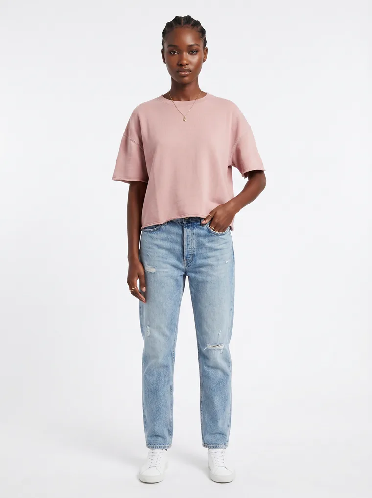 A blush boxy tee with light wash straight jeans and white sneakers on pale grey. Boxy Tee in Blush, frame 1 of 5