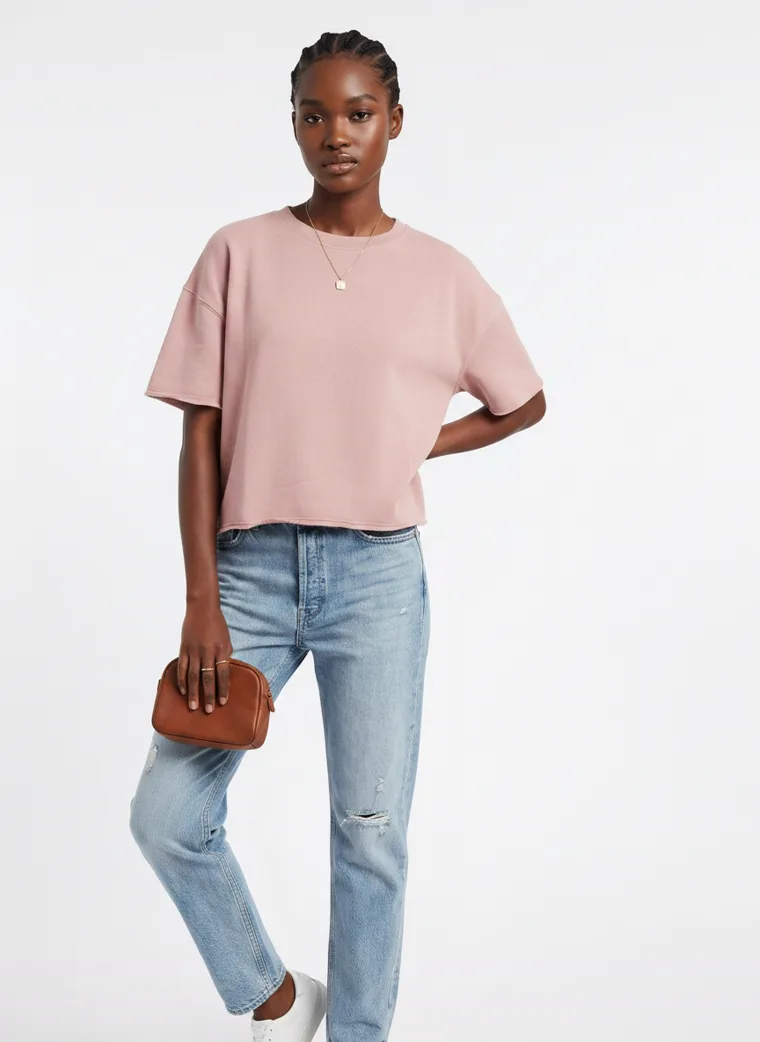A blush boxy tee with light wash straight jeans and white sneakers on pale grey. Boxy Tee in Blush, frame 3 of 5