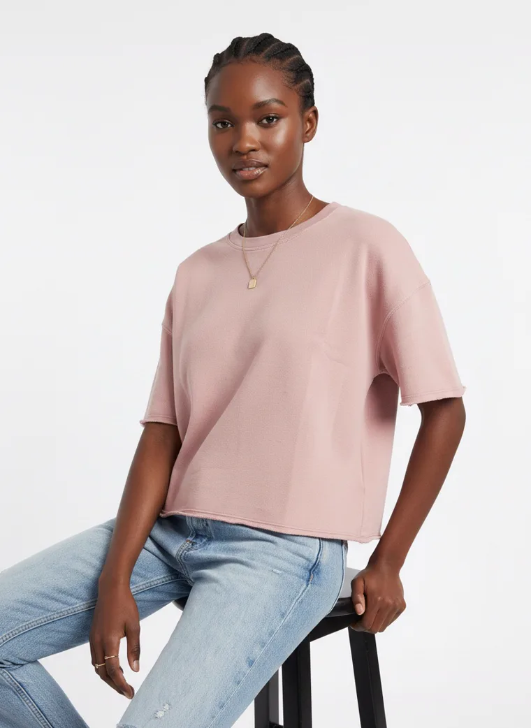 A blush boxy tee with light wash straight jeans and white sneakers on pale grey. Boxy Tee in Blush, frame 5 of 5