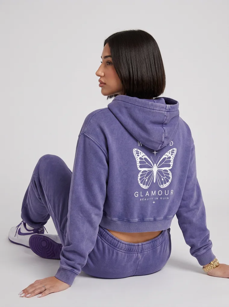 A washed violet cropped hoodie with a butterfly back print and matching sweatpants on pale grey. Cropped Hoodie Set in Violet, frame 2 of 5