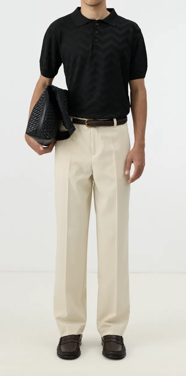 Input photo — a black polo and cream trousers on a person with the head cropped out of frame