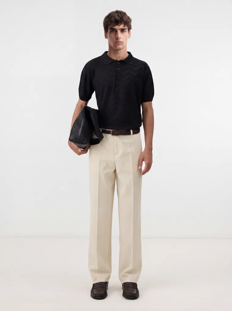 MODA AI output — the black polo and cream trousers on a full-length male model in a clean studio