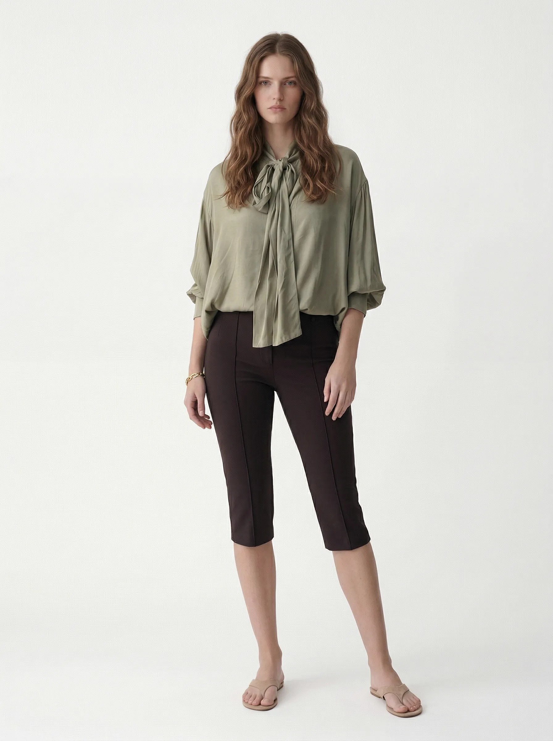 MODA AI output 1 — studio model wearing olive tie-neck blouse with chocolate capris, model-to-model swap with full fit accuracy