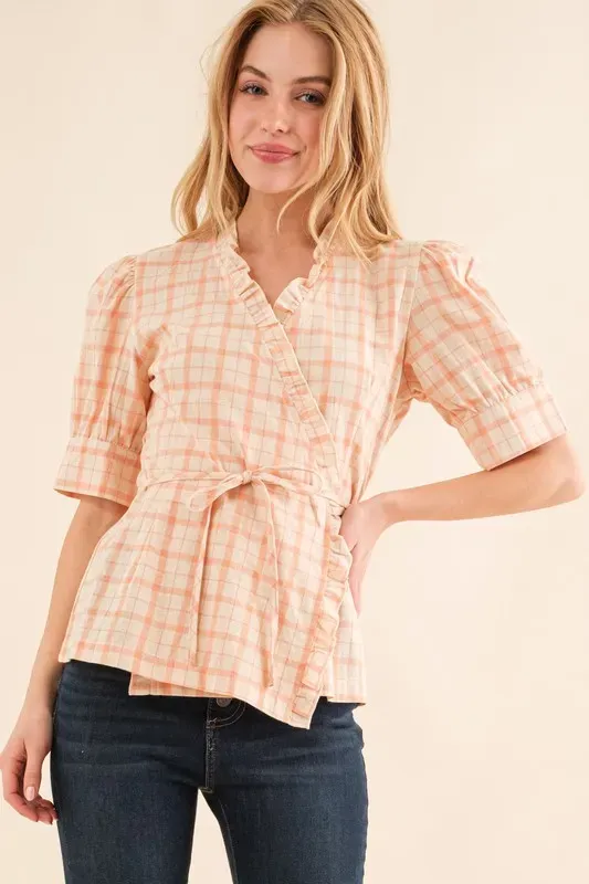 On-body reference — headshot crop of a real model wearing peach plaid wrap top