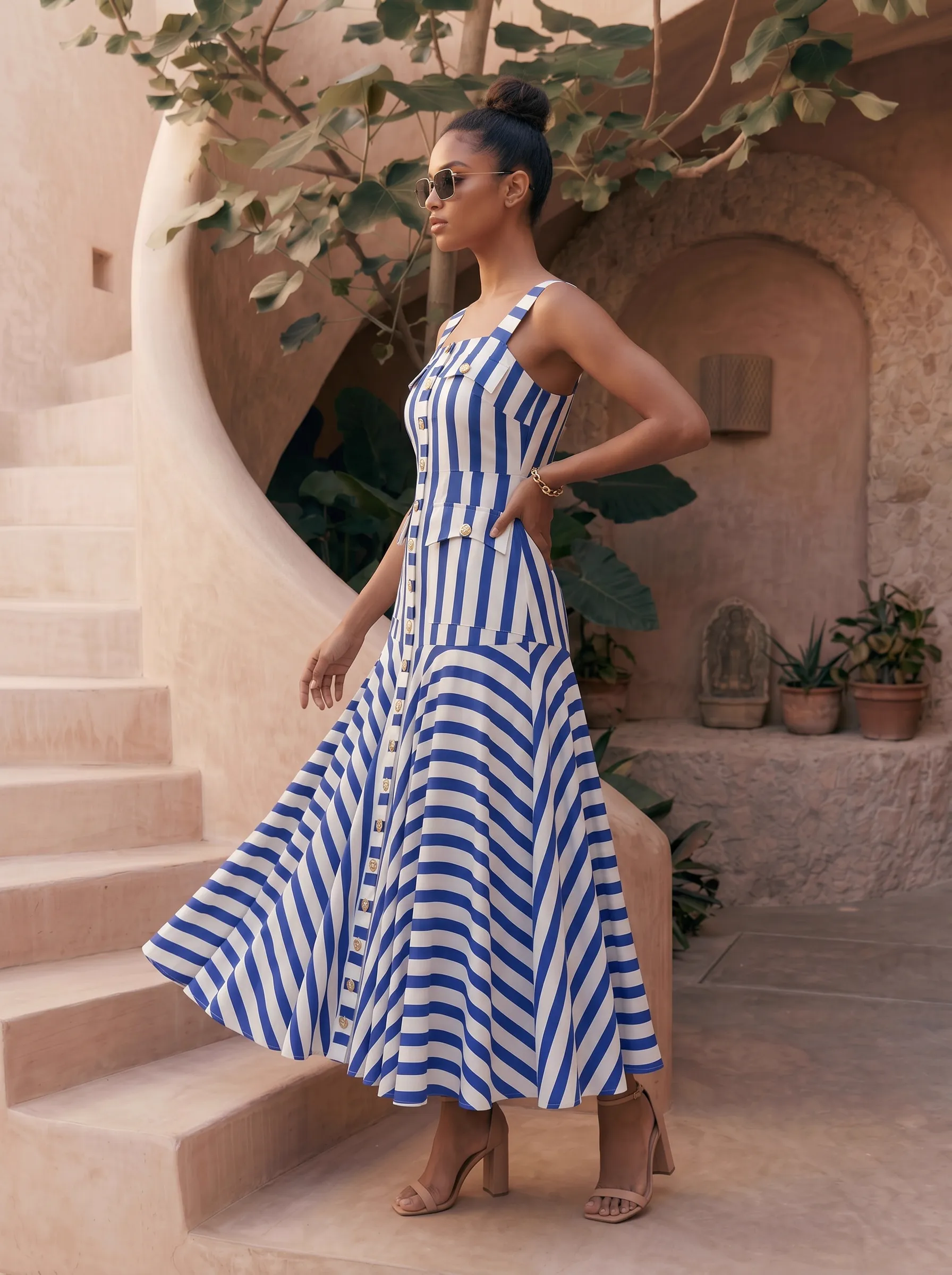 MODA AI resortwear output — blue and white striped maxi dress on Marrakech spiral mud staircase