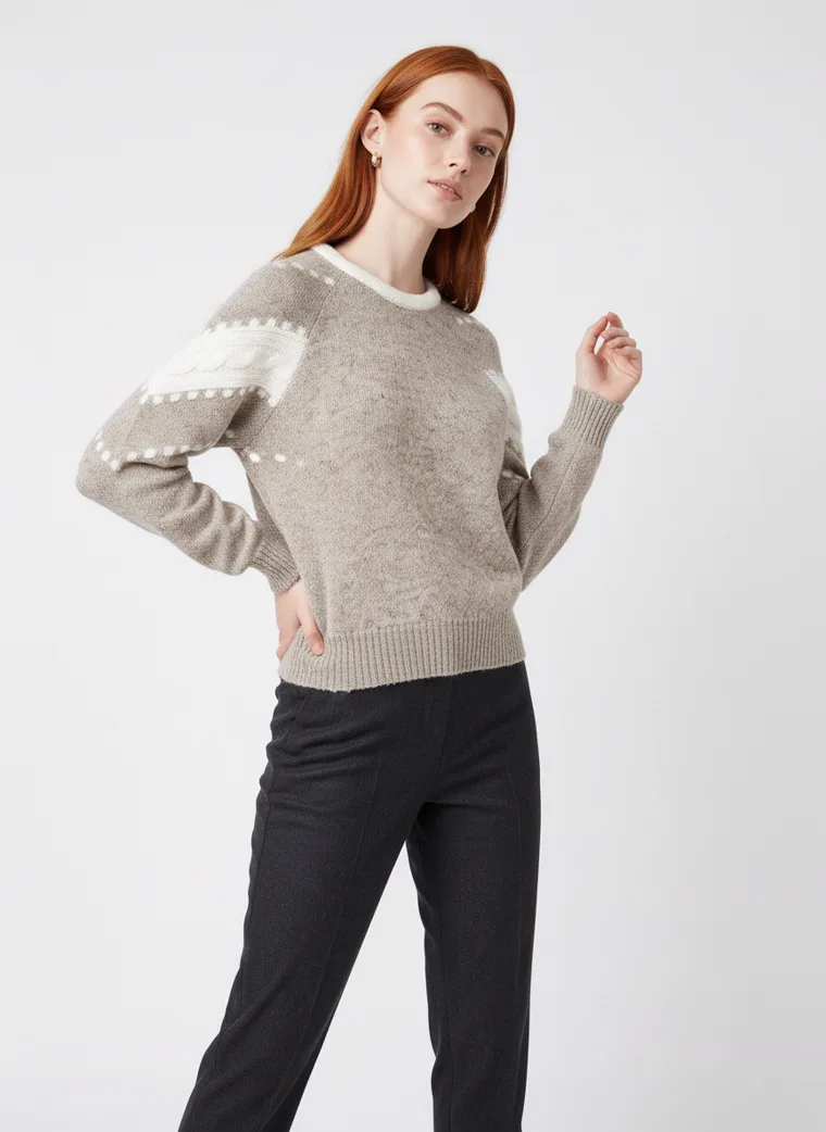 A grey marled crew-neck knit with white intarsia stripes and dots down the sleeves and a cream neckline, worn with black trousers. Intarsia Stripe Knit in grey, three-quarter