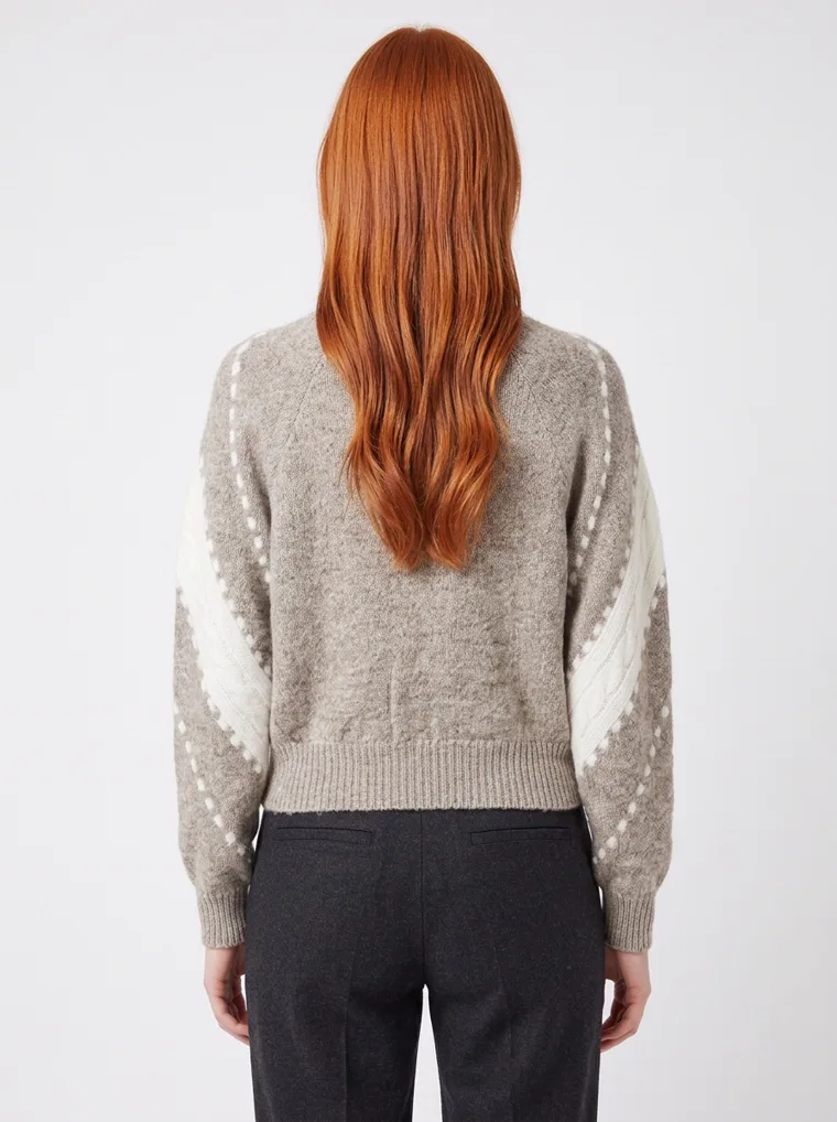A grey marled crew-neck knit with white intarsia stripes and dots down the sleeves and a cream neckline, worn with black trousers. Intarsia Stripe Knit in grey, back view
