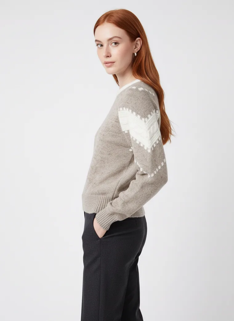 A grey marled crew-neck knit with white intarsia stripes and dots down the sleeves and a cream neckline, worn with black trousers. Intarsia Stripe Knit in grey, three-quarter, full length