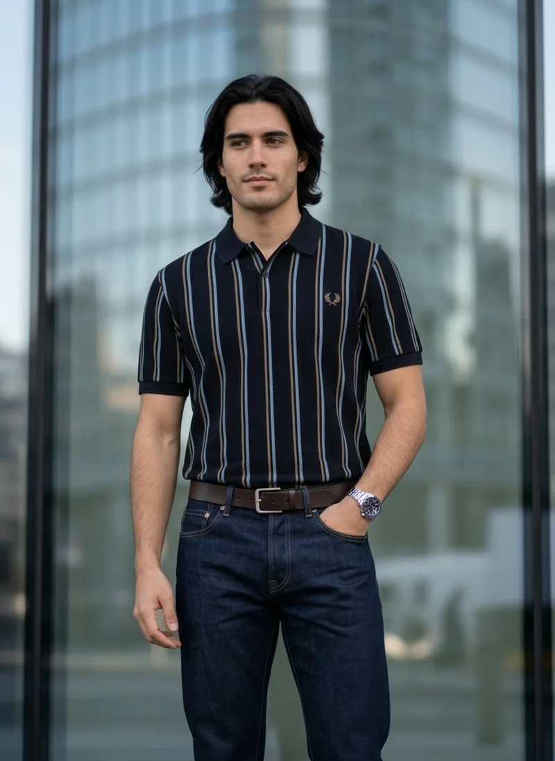 MODA AI catalog shot 3 of 10, front, hands in pockets. The striped navy polo, the same generated male model throughout, in a city setting