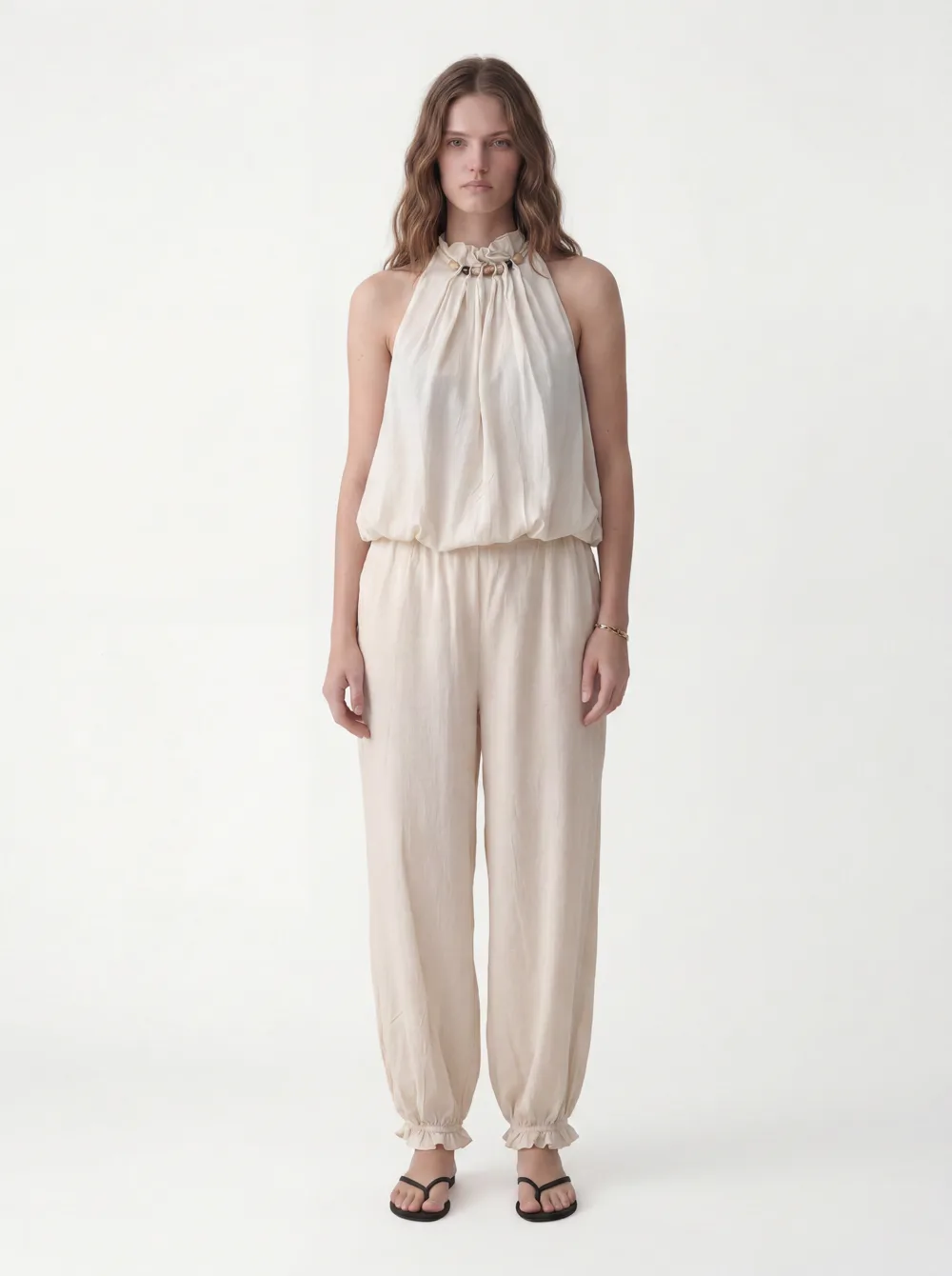 MODA output — a complete generated model with full head and face, clean white studio, 3:4 portrait, wearing the cream halter jumpsuit