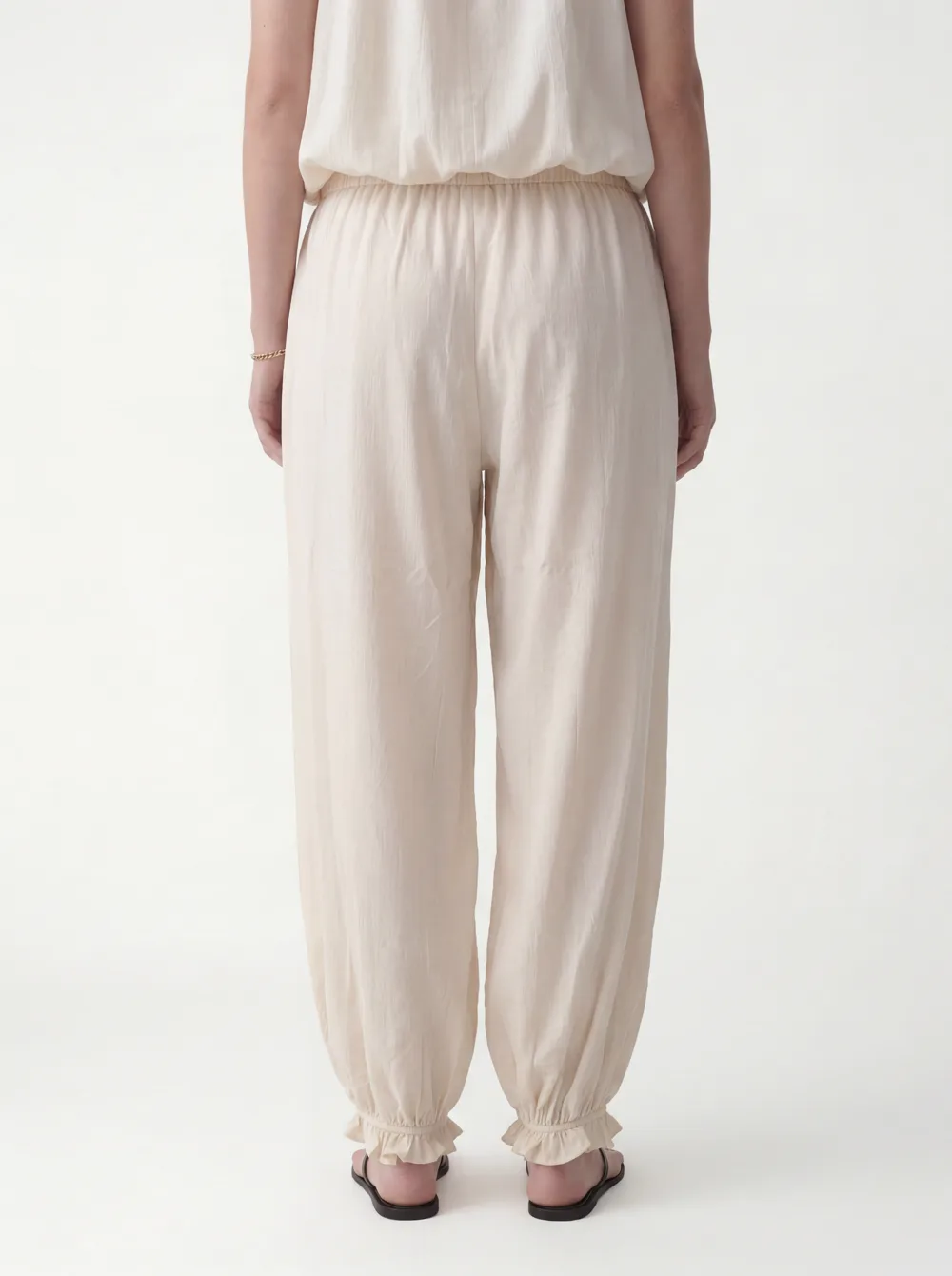 MODA catalog shot 10 of 10 — the generated model in the cream halter jumpsuit, consistent across every angle