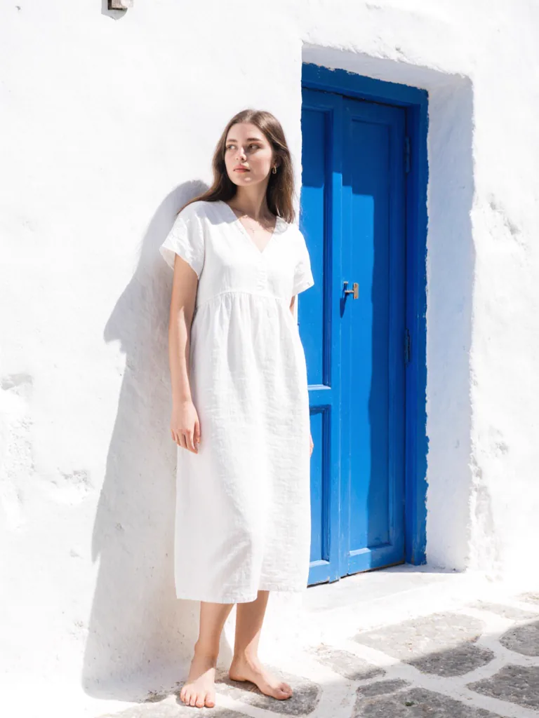 MODA reference library — Greek island white stucco. A model look and background scene merchants can use as reference inputs for their own catalog set.